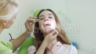 在牙医那里做牙齿检查的年轻女子。 专业口腔检查